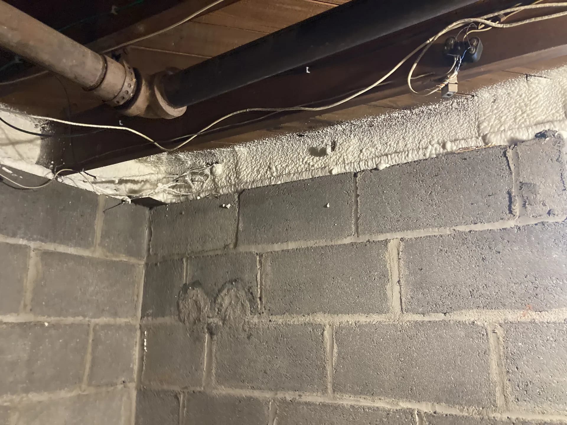Spray foam sealing the rim joist of a basement